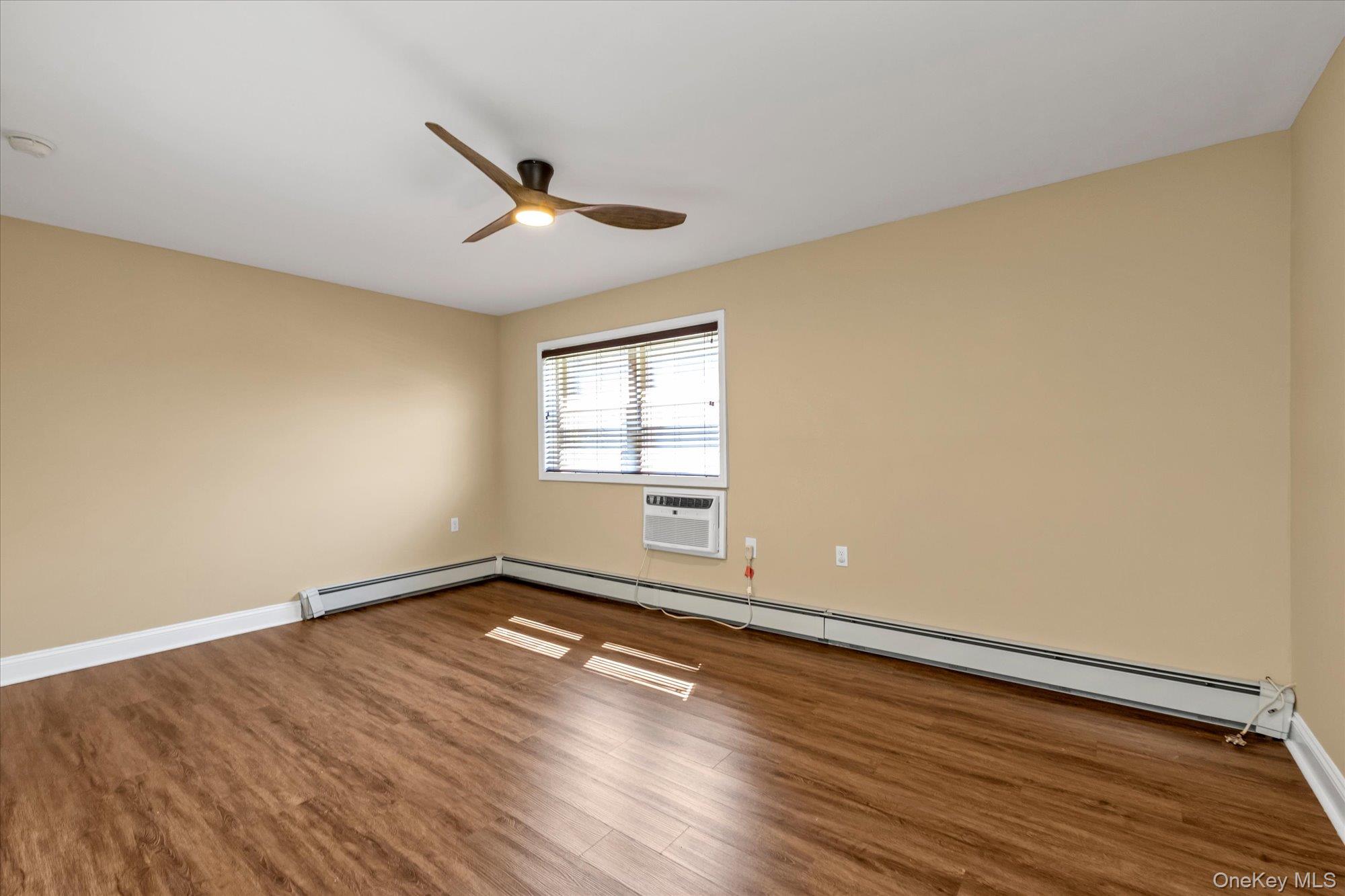 4 Rose Street, Unit 5H1 Oceanside, NY 11572 - Photo 10 of 18 a view of empty room with wooden floor and fan
