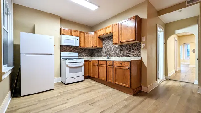 a kitchen with a refrigerator wooden floor and a sink