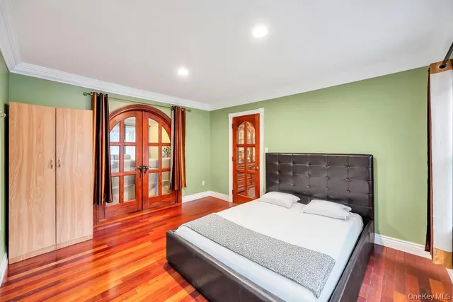 a bedroom with a large bed and wooden floor