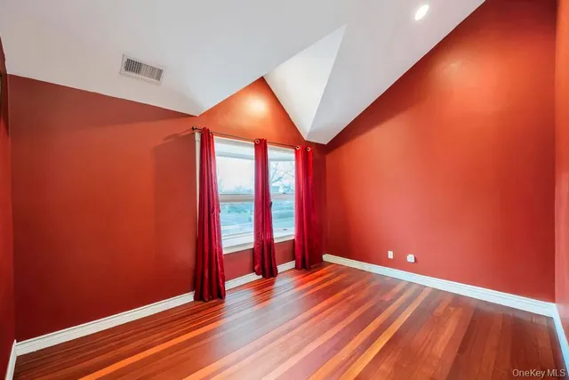 an empty room with wooden floor and closet