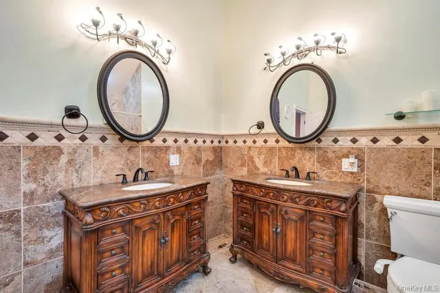 a bathroom with a sink a toilet and a mirror