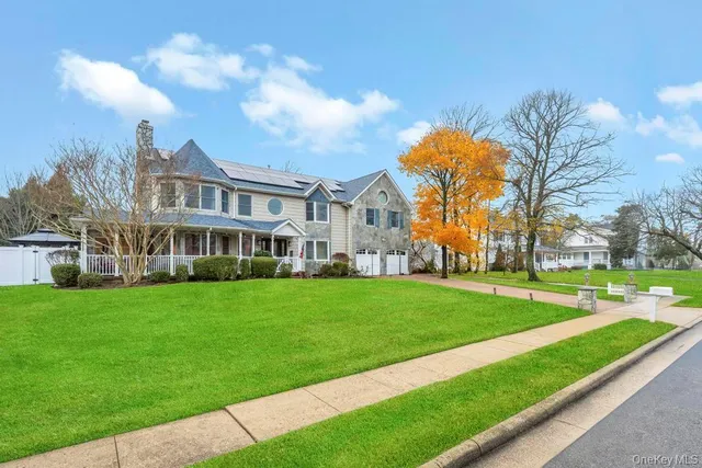 a view of a big house with a big yard and large trees
