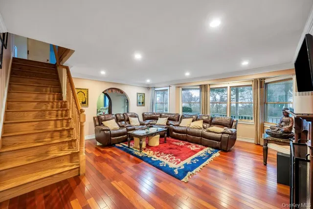 a living room with furniture hard wood floor and a flat screen tv