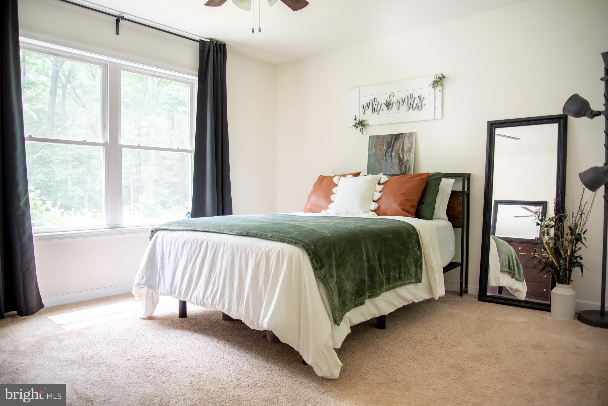 5588 Courtneys Corner Road Sumerduck, VA 22742 - Photo 15 of 22 a bedroom with a bed lamp and a large window