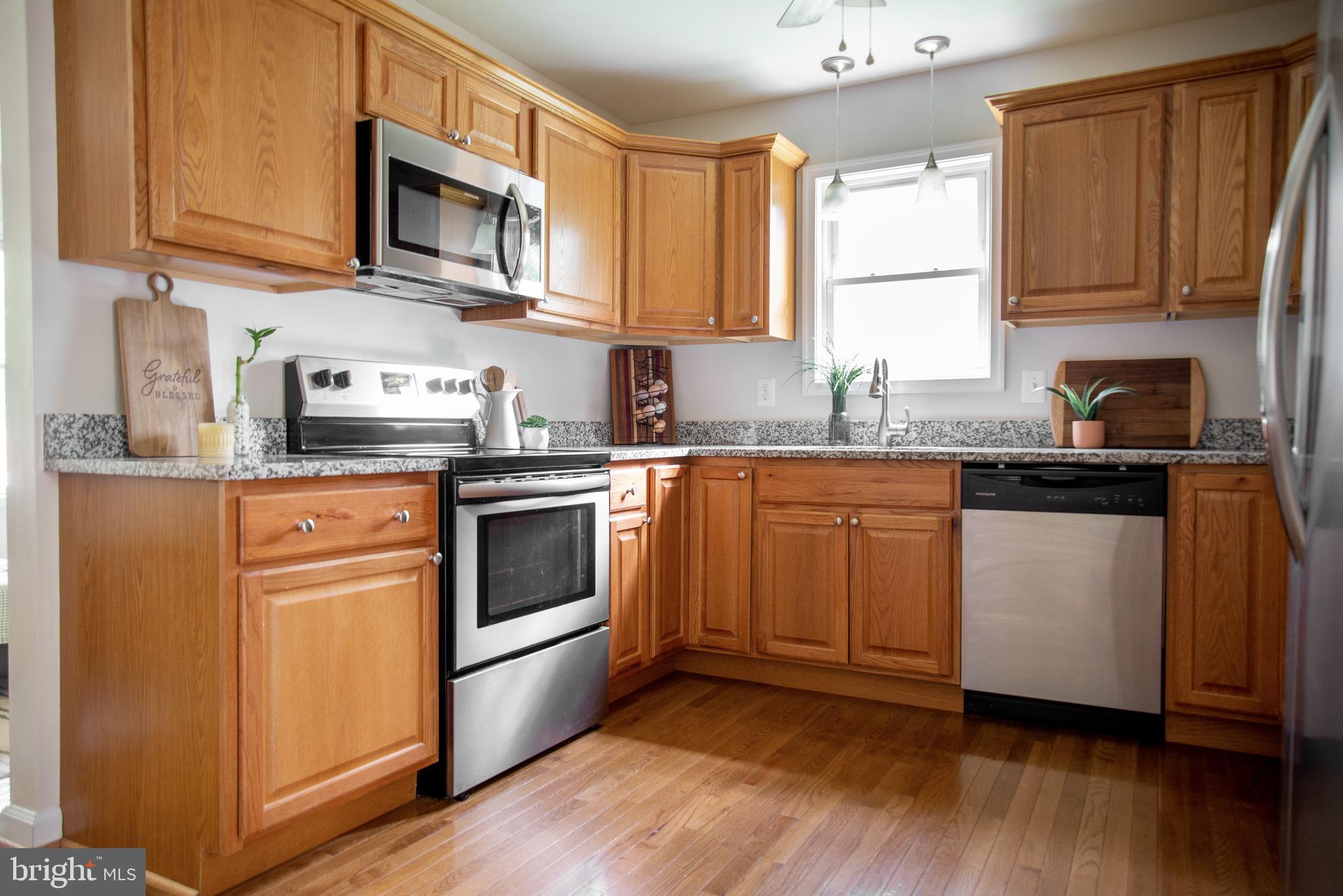 5588 Courtneys Corner Road Sumerduck, VA 22742 - Photo 8 of 22 a kitchen with stainless steel appliances granite countertop a sink a stove a microwave and cabinets