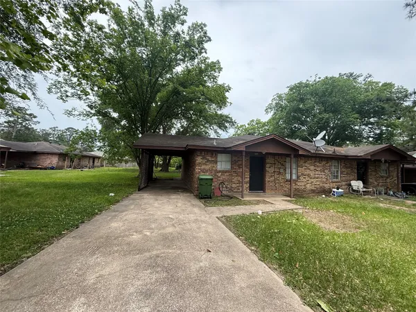 a front view of a house with a yard and trees