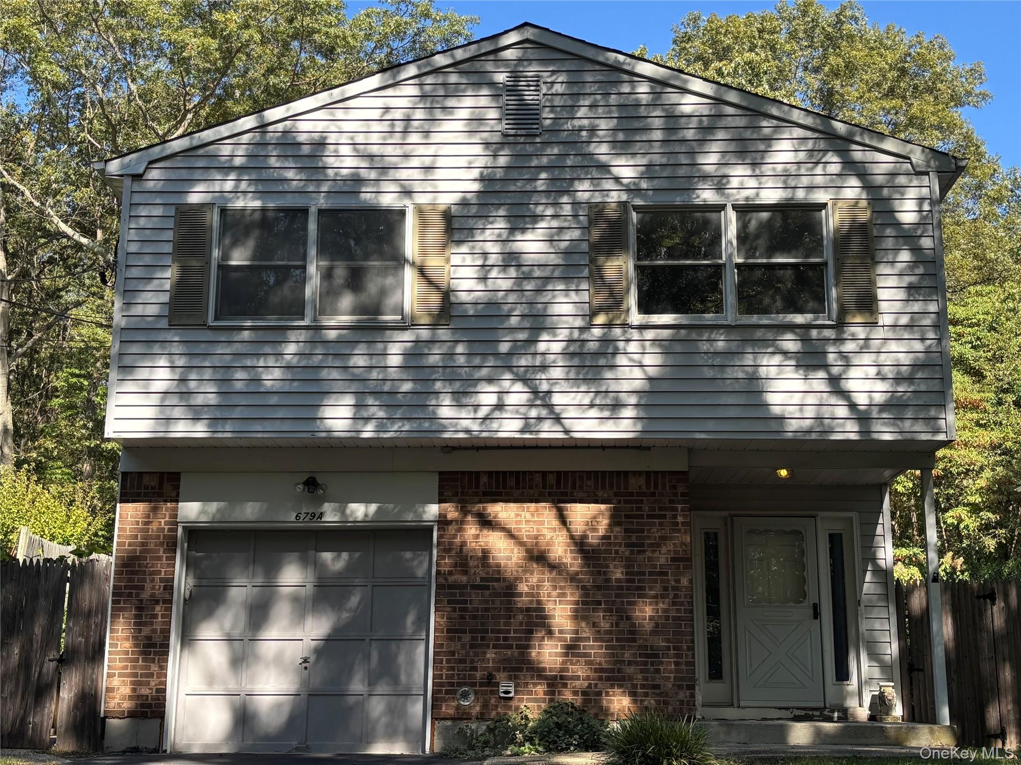 View of front of home with brick siding and a garage