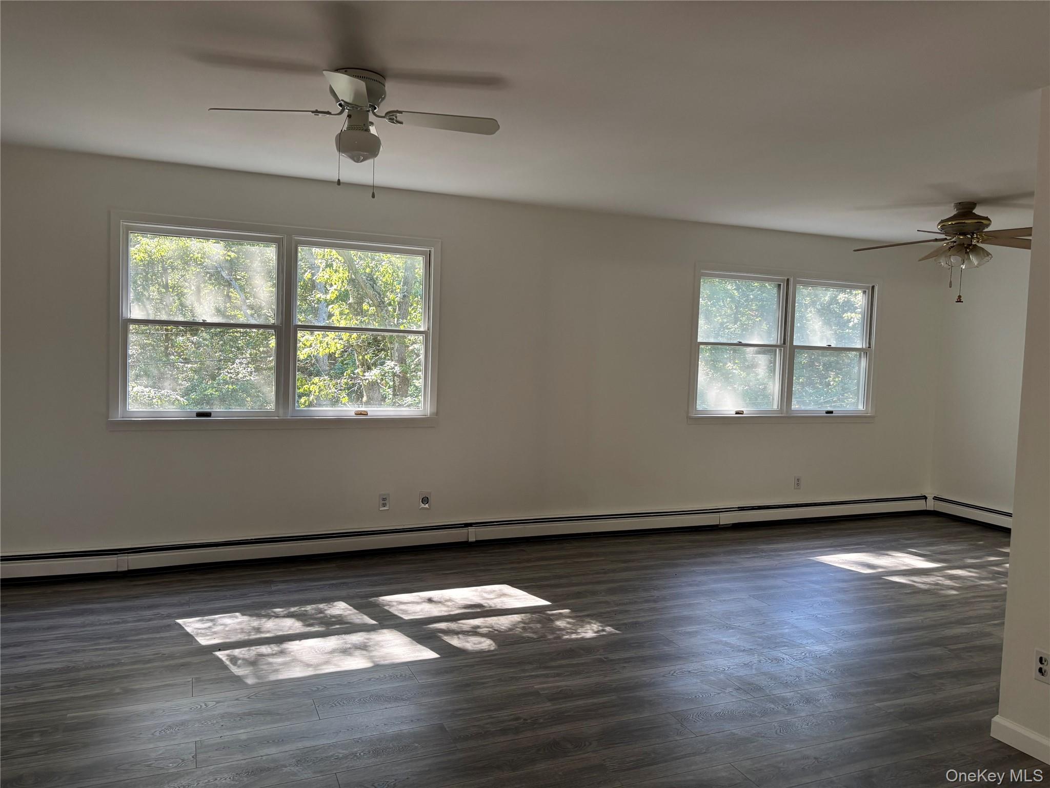 679 A Meadow Road Smithtown, NY 11787 - Photo 17 of 30 Spare room with ceiling fan, a baseboard radiator, and dark wood finished floors