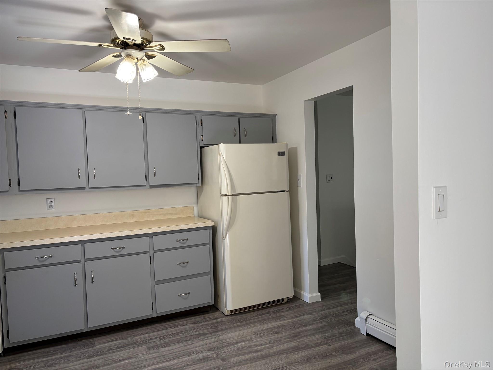 679 A Meadow Road Smithtown, NY 11787 - Photo 19 of 30 Kitchen with gray cabinets, freestanding refrigerator, light countertops, a baseboard radiator, and ceiling fan