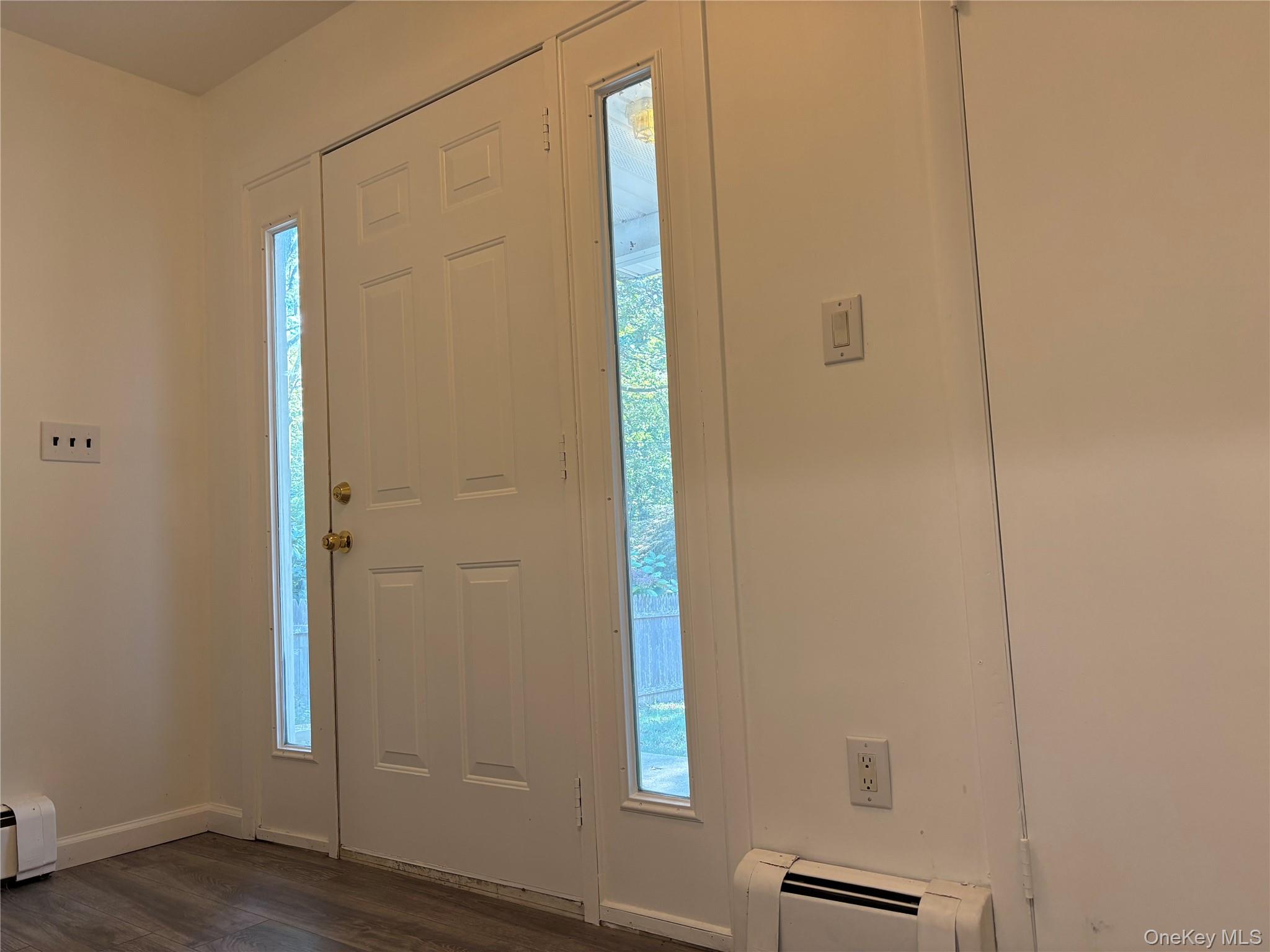 679 A Meadow Road Smithtown, NY 11787 - Photo 2 of 30 Entrance foyer with a baseboard radiator, dark wood-style flooring, and baseboard heating
