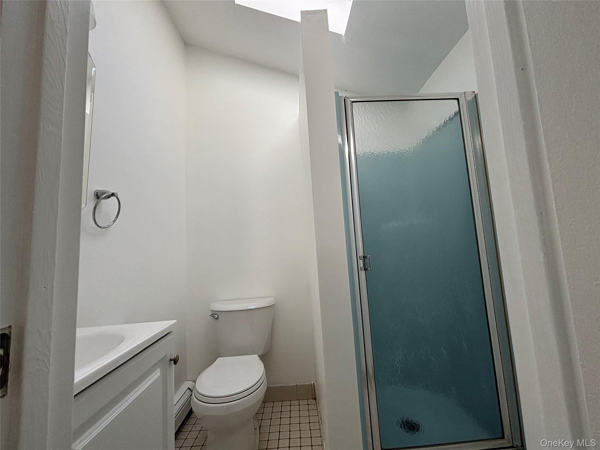 679 A Meadow Road Smithtown, NY 11787 - Photo 24 of 30 Full bath with vanity, light tile patterned flooring, a stall shower, and a baseboard radiator