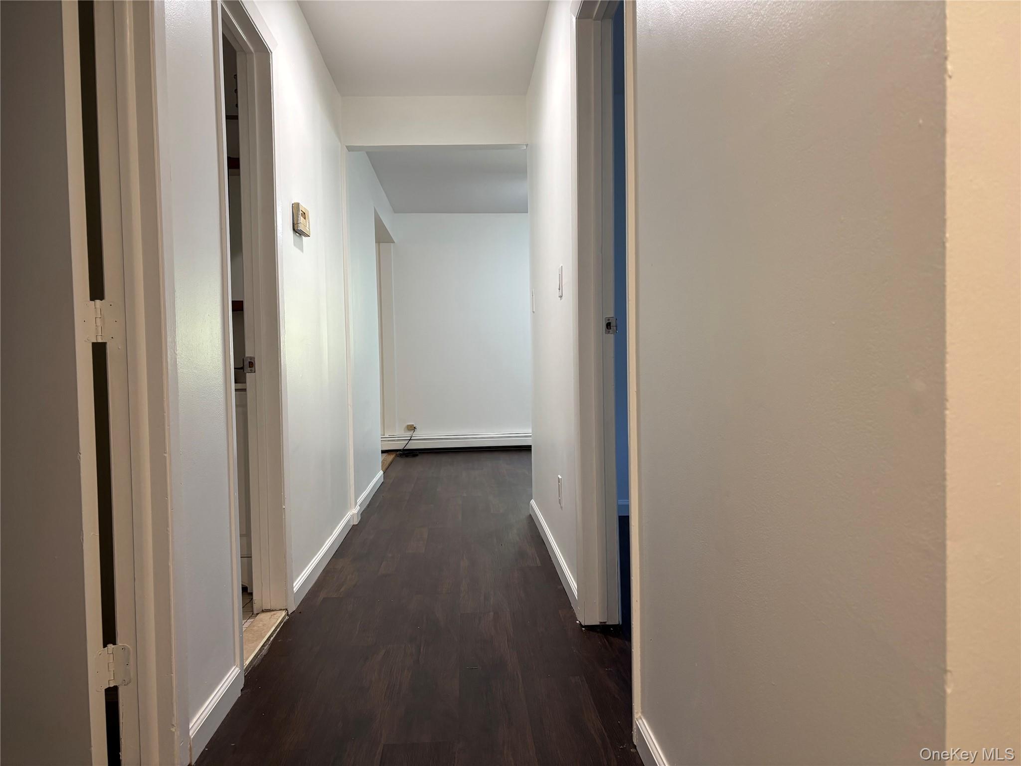 679 A Meadow Road Smithtown, NY 11787 - Photo 4 of 30 Hall with dark wood finished floors and baseboard heating