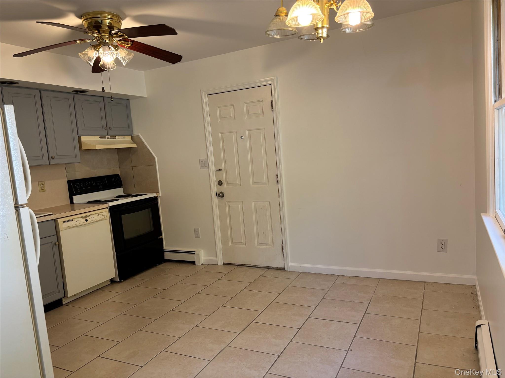679 A Meadow Road Smithtown, NY 11787 - Photo 6 of 30 Kitchen featuring gray cabinets, white appliances, light tile patterned floors, light countertops, and a baseboard heating unit