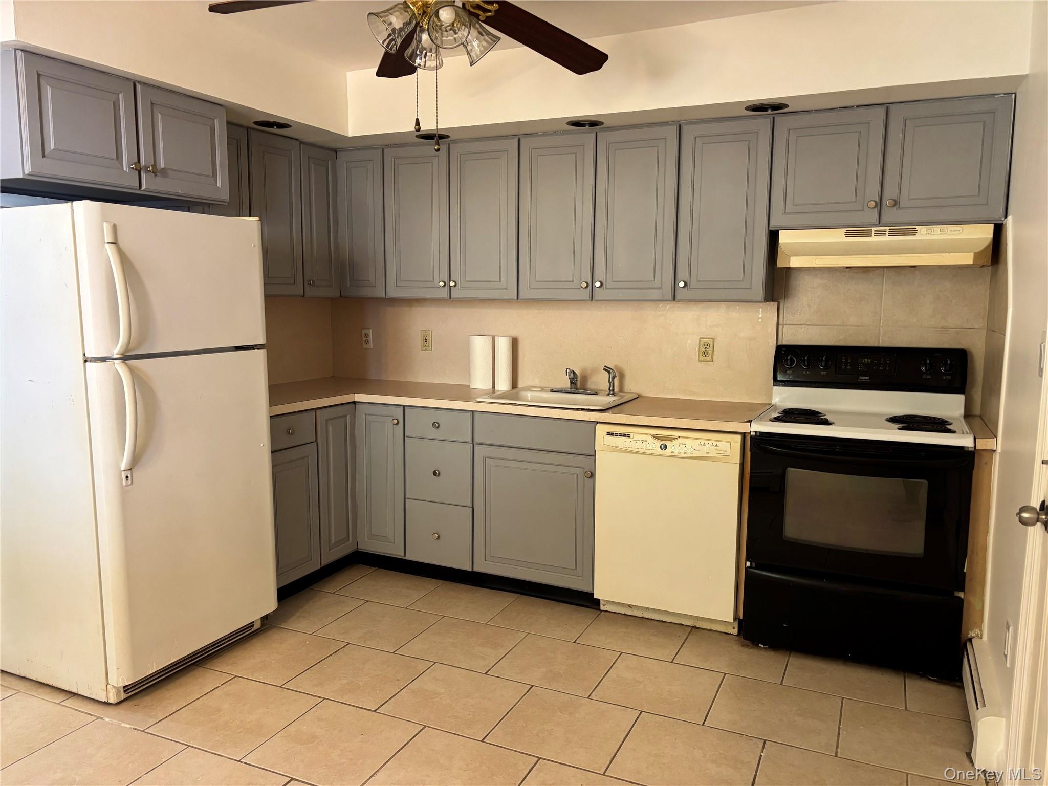 679 A Meadow Road Smithtown, NY 11787 - Photo 7 of 30 Kitchen featuring white appliances, gray cabinetry, light countertops, and under cabinet range hood