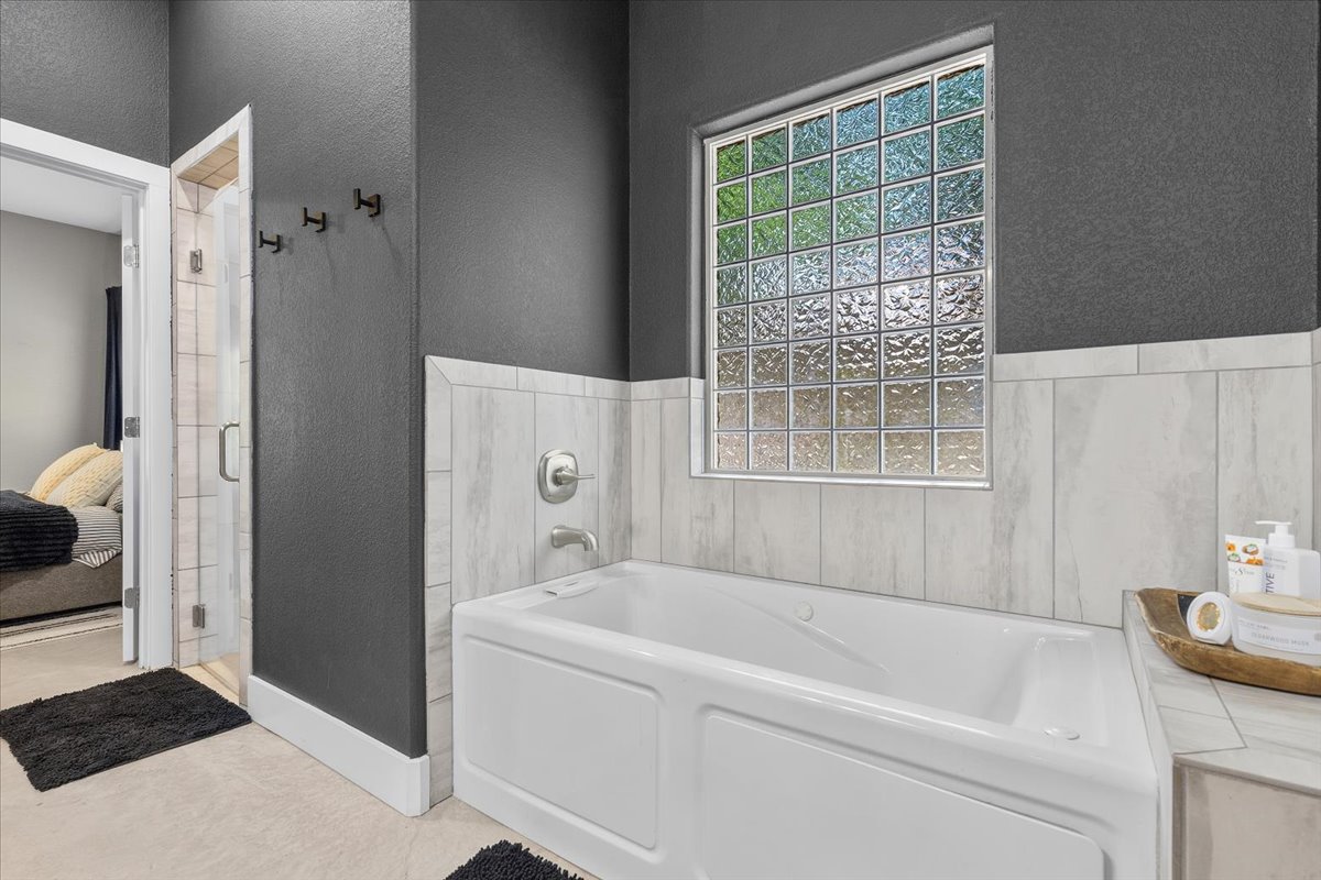 145 Cardinal Loop Paige, TX 78659 - Photo 24 of 40 A well-lit soaking tub offers a private retreat, complemented by a glass block window for natural light.