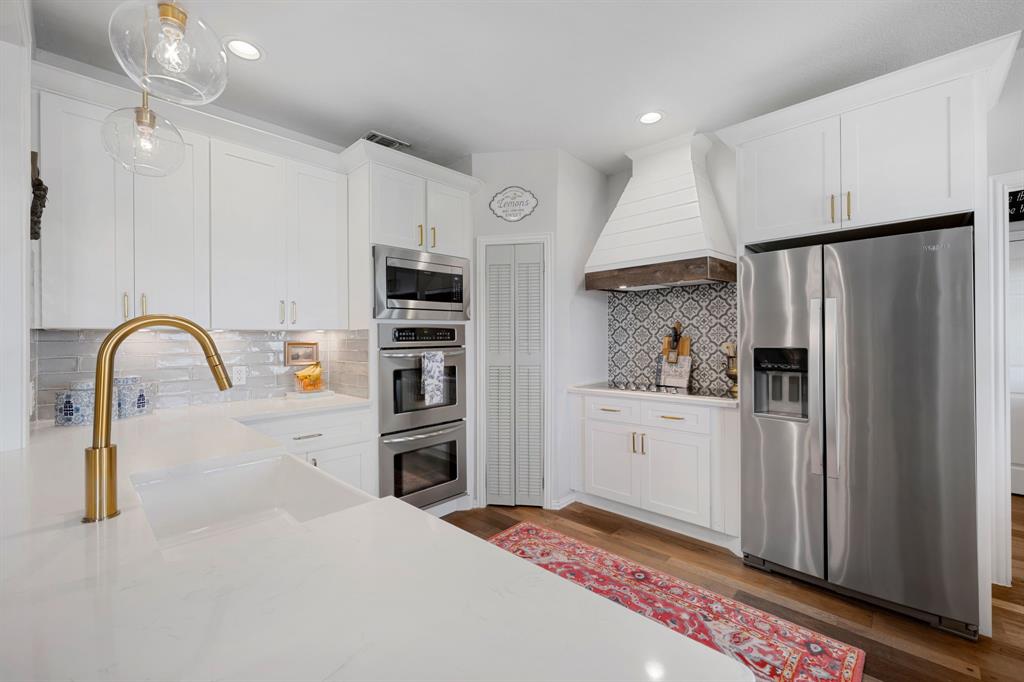 965 Stonecrest Road Argyle, TX 76226 - Photo 13 of 29 Kitchen with new stainless steel appliances, white cabinetry, and quartz countertops.
