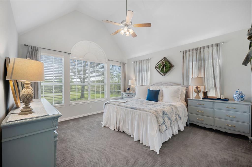 965 Stonecrest Road Argyle, TX 76226 - Photo 16 of 29 Primary bedroom featuring expansive windows that look out to the backyard, ceiling fan, and a high ceiling