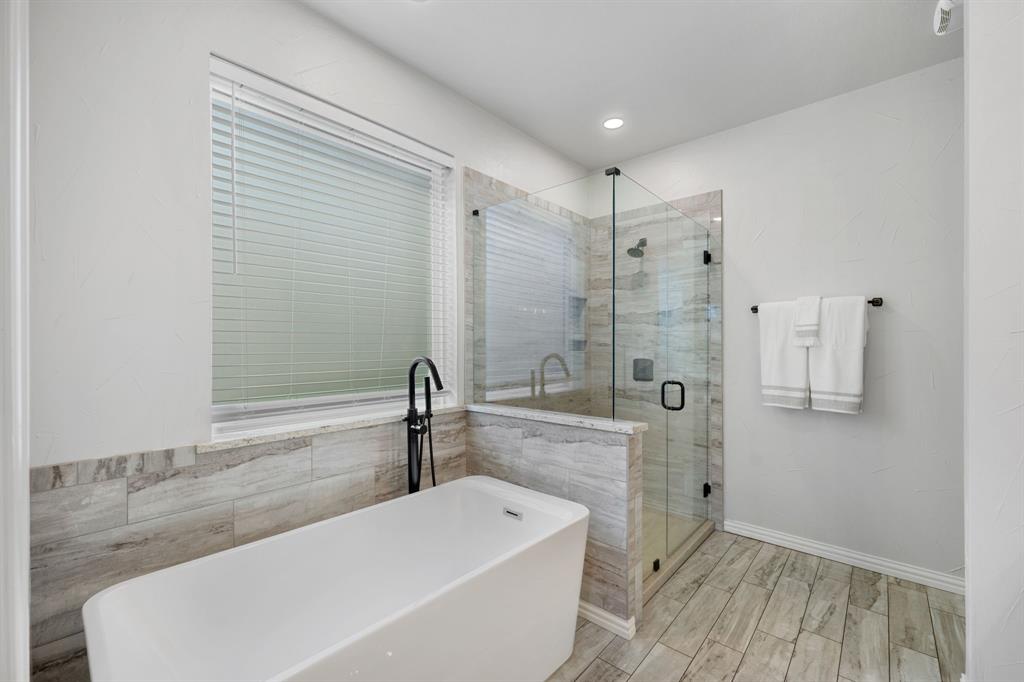 965 Stonecrest Road Argyle, TX 76226 - Photo 18 of 29 Updated primary bathroom featuring a porcelain tile shower, a freestanding tub
