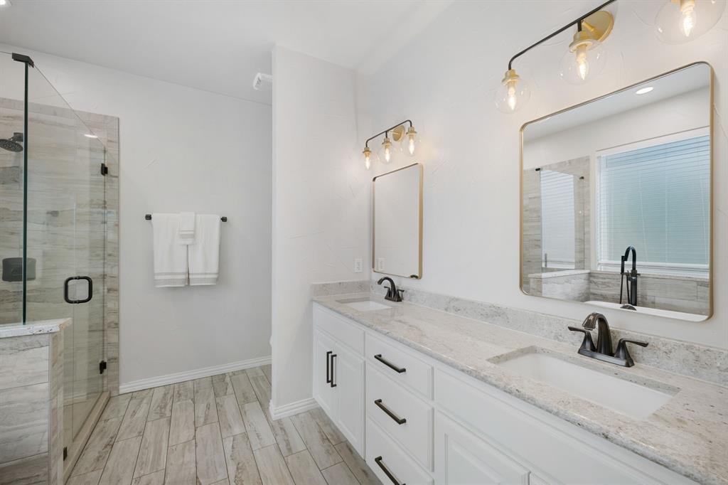 965 Stonecrest Road Argyle, TX 76226 - Photo 19 of 29 Primary bath featuring double vanity with ample amount of storage, a walk in shower with porcelain tiled floors and granite countertops
