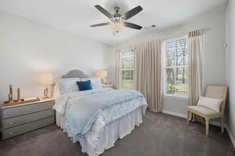 a bedroom with a bed and a ceiling fan