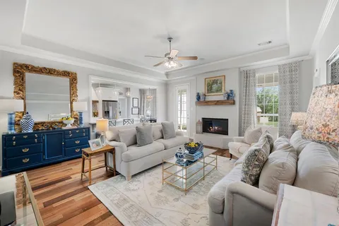 a living room with furniture kitchen view and a chandelier
