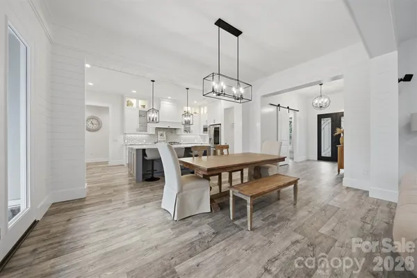 a dining room with furniture a chandelier and wooden floor