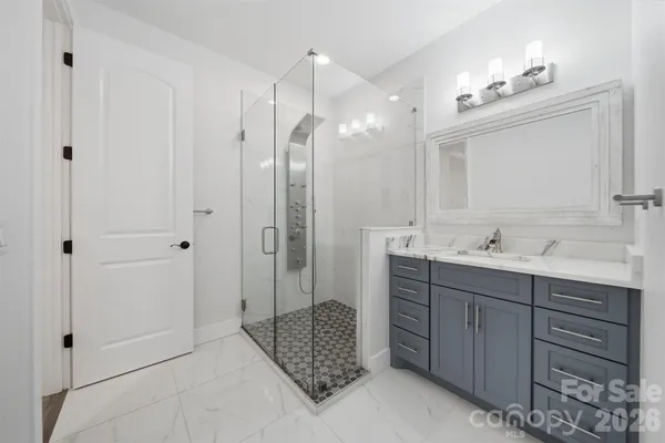 a bathroom with a double vanity sink mirror and shower