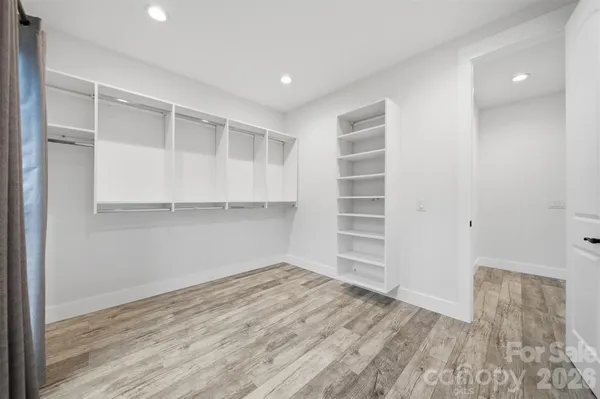 a view of walk in closet with empty racks