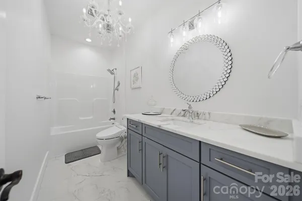 a bathroom with a granite countertop sink a toilet and a mirror