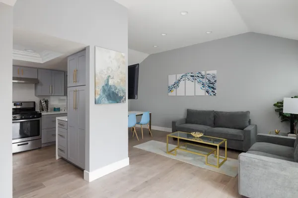a living room with furniture and a kitchen view