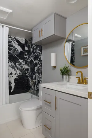 a bathroom with a sink a toilet and shower