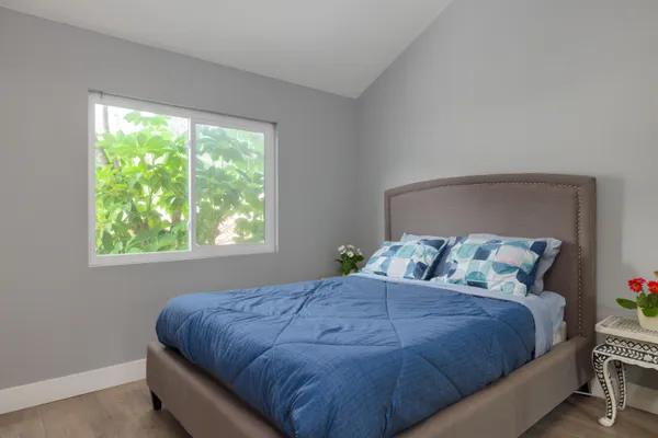 a large bed sitting in a bedroom next to a window