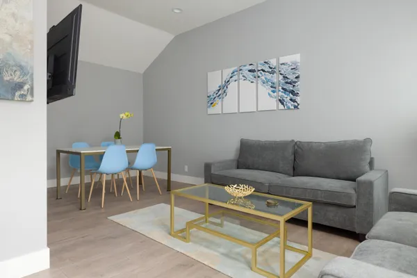 a living room with furniture a flat screen tv and a rug