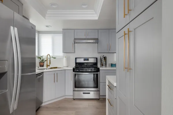 a kitchen with stainless steel appliances granite countertop a refrigerator and a sink