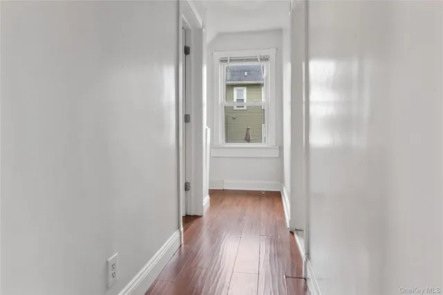 a view of a room with wooden floor and a bathroom