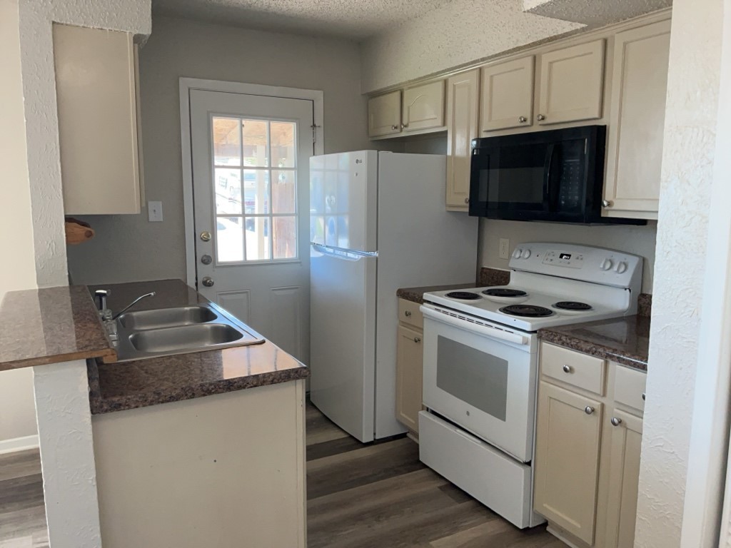 512 Lenora Drive, Unit B Taylor, TX 76574 - Photo 5 of 11 a kitchen with a stove and a microwave