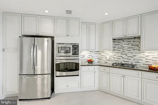 a kitchen with white cabinets white appliances and sink