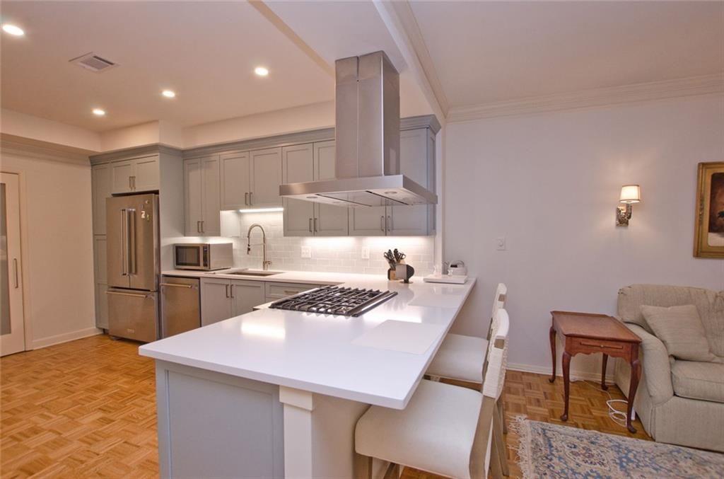2734 Peachtree Road Northwest, Unit C101 Atlanta, GA 30305 - Photo 6 of 23 a kitchen with a table chairs stove and refrigerator