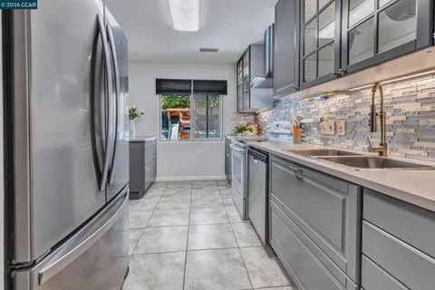 a kitchen with stainless steel appliances granite countertop a refrigerator and a sink