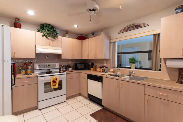 a kitchen with a sink a refrigerator and cabinets
