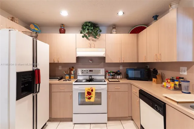 a kitchen with a white stove top oven and refrigerator