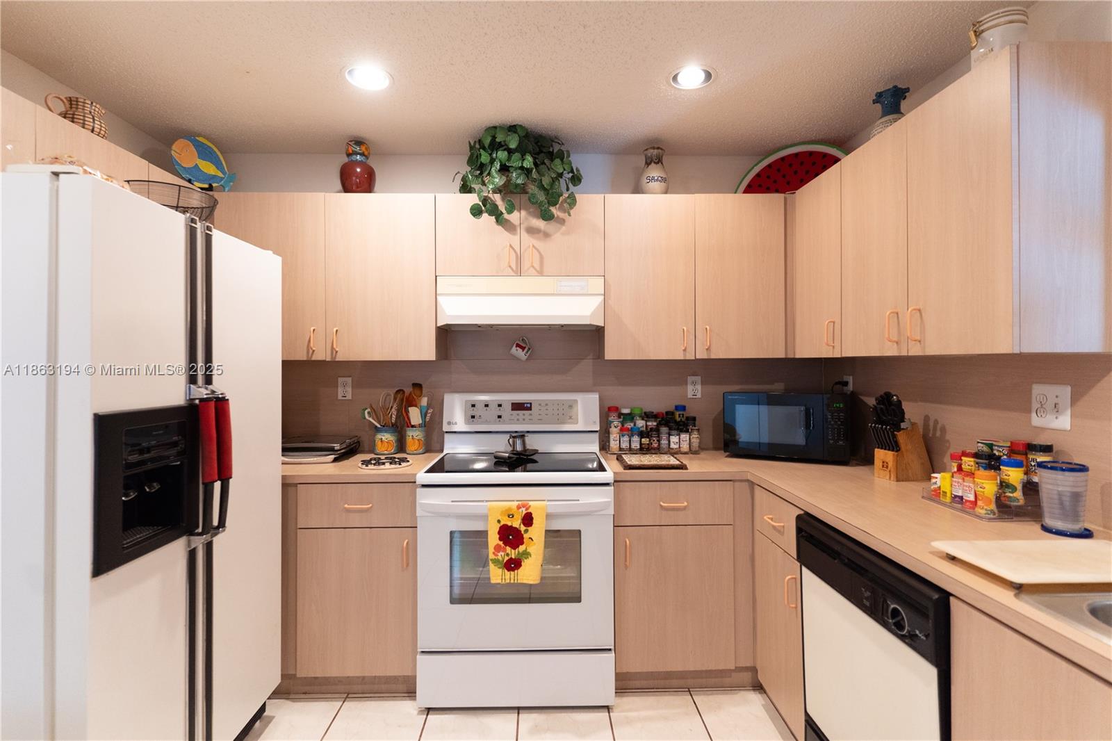 11680 Southwest 92nd Street Miami, FL 33176 - Photo 12 of 44 a kitchen with a sink a refrigerator and cabinets
