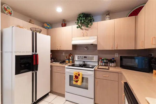 a kitchen with a white stove top oven and refrigerator