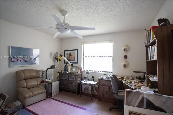 a living room with furniture a desk and a window