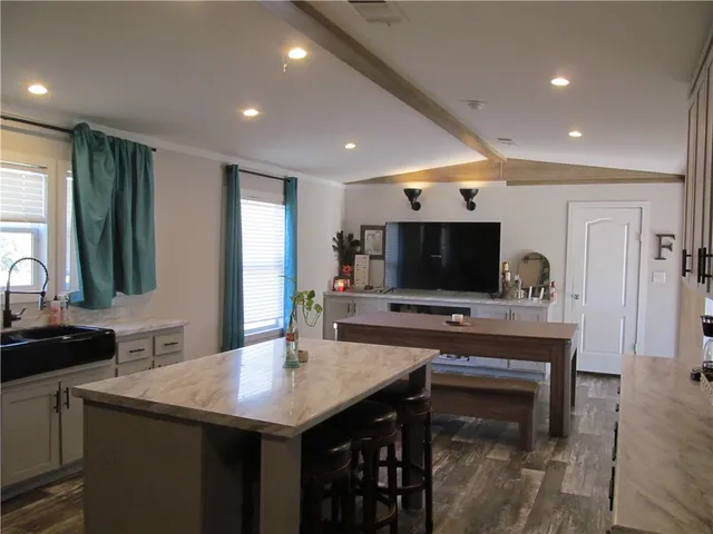 a kitchen with a sink and living room view