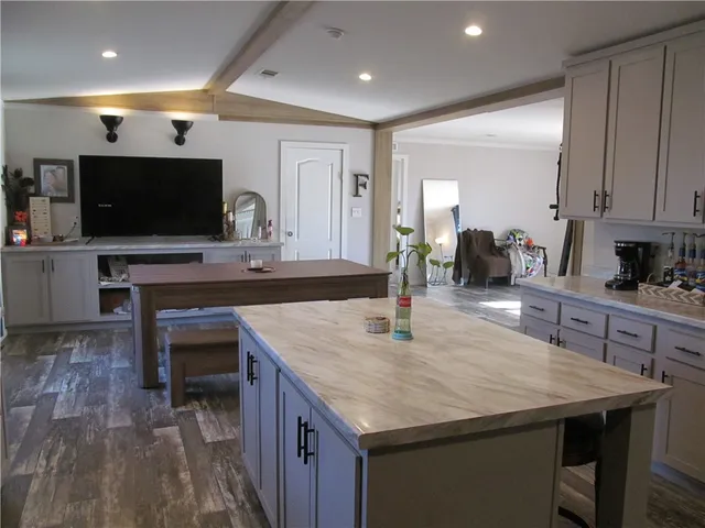 a kitchen with granite countertop a table chairs sink and cabinets
