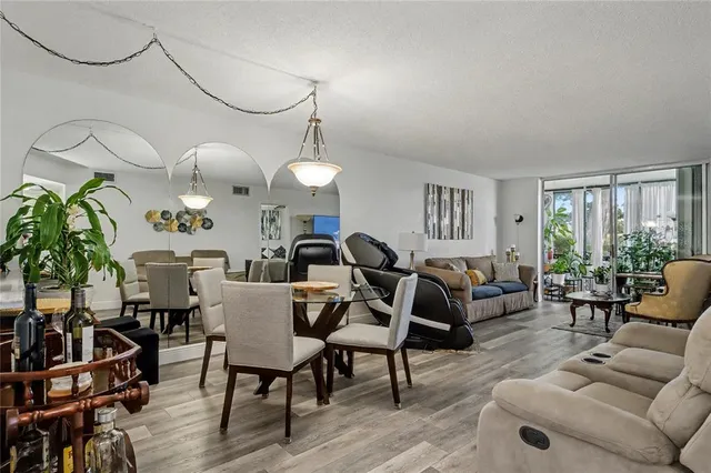 a living room with furniture kitchen view and a large window