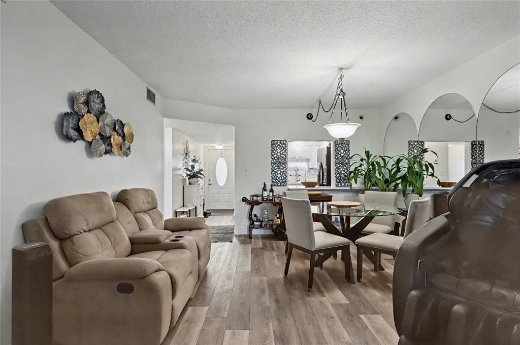 9520 South Hollybrook Lake Drive, Unit 103 Pembroke Pines, FL 33025 - Photo 8 of 55 a living room with couches painting on the wall and a potted plant