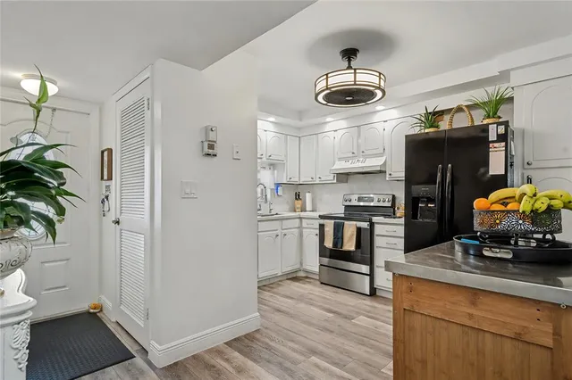 a kitchen with stainless steel appliances a stove a refrigerator and a hard wood floor
