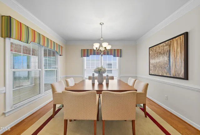 a dining room with furniture a chandelier and wooden floor